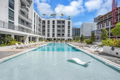 a large swimming pool with lounge chairs and buildings at Modern Unit in Downtown Miami With Free Parking in Miami