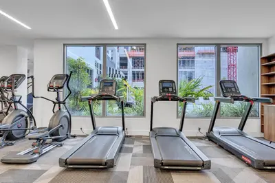 a gym with cardio machines in a room with windows at Modern Unit in Downtown Miami With Free Parking in Miami