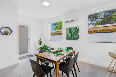 a dining room with a wooden table and chairs at Up to 16 guests! Modern house near Wynwood in Miami