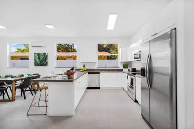 a kitchen with white cabinets and a stainless steel refrigerator at Up to 16 guests! Modern house near Wynwood in Miami