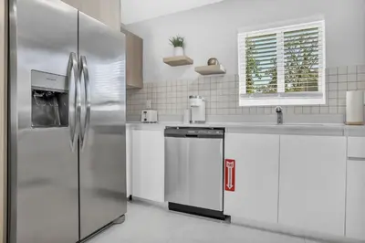 a kitchen with a stainless steel refrigerator and white cabinets at Sistrunk Shades Villas #2 New Downtown Fort Lauderdale Townhomes in Fort Lauderdale