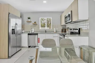 a kitchen with white cabinets and a stainless steel refrigerator at Sistrunk Shades Villas #2 New Downtown Fort Lauderdale Townhomes in Fort Lauderdale