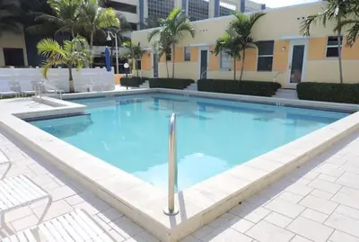 a large blue swimming pool in front of a building at 310 Oasis Paradise in Hollywood