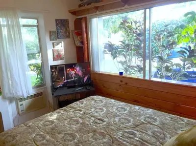 a bedroom with a bed and a large window at Miami Bungalow Oasis near Everglades & The Keys in Cutler Bay