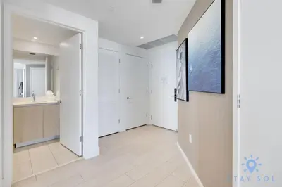 a hallway with a bathroom and a tv on a wall at Luxury 2Br Front Ocean Bay View Amazing Pools in Hollywood