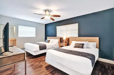a bedroom with two beds and a flat screen tv at Wonderful 4BR and 3BA Villa Heated Pool near Beach in Hollywood