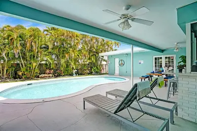 a house with a swimming pool with a ceiling fan at Wonderful 4BR and 3BA Villa Heated Pool near Beach in Hollywood