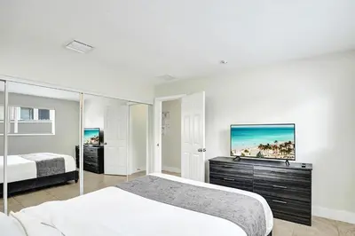 a bedroom with two beds and a tv on the wall at Luxury Villa with Heated Pool close to Beach in Hollywood