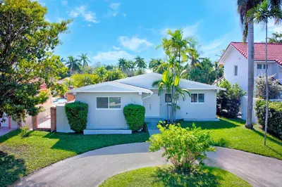 a white house with palm trees in a yard at Luxury Villa with Heated Pool close to Beach in Hollywood