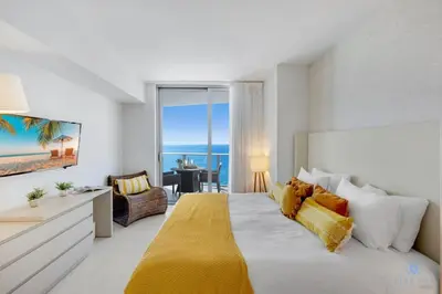 a bedroom with a large bed with a view of the ocean at Insane Ocean View Balcony Beachfront Condo Pool in Hollywood