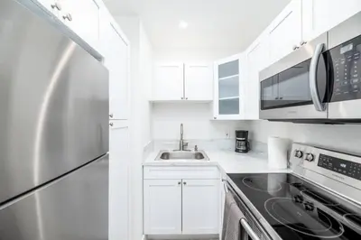 a white kitchen with a sink and a refrigerator at Heart Of Wilton 1 Recently Remodeled in Fort Lauderdale