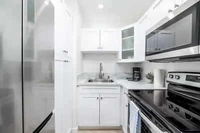 a white kitchen with a sink and a refrigerator at Heart of Wilton 3 Recently Remodeled in Fort Lauderdale