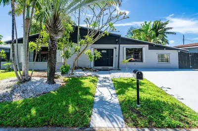 a house with palm trees and a parking meter at Heated Pool Tropical Backyard 3 Bedrooms, 12 min to the Ocean in North Miami Beach