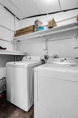 a laundry room with two washing machines and shelves at Heated Pool Tropical Backyard 3 Bedrooms, 12 min to the Ocean in North Miami Beach