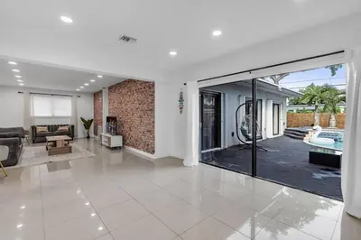 a living room with a large sliding glass door at Heated Pool Tropical Backyard 3 Bedrooms, 12 min to the Ocean in North Miami Beach