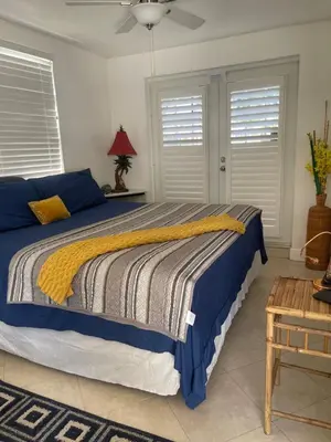 a bedroom with a bed with a yellow and blue blanket at Stunning suite by hard rock stadium and casino in Miami
