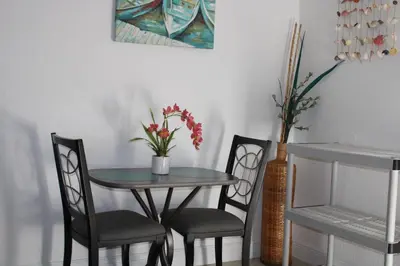 a table and two chairs and a table with flowers on it at Stunning suite by hard rock stadium and casino in Miami