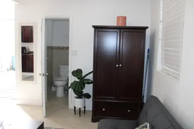 a living room with a brown cabinet and a toilet at Stunning suite by hard rock stadium and casino in Miami