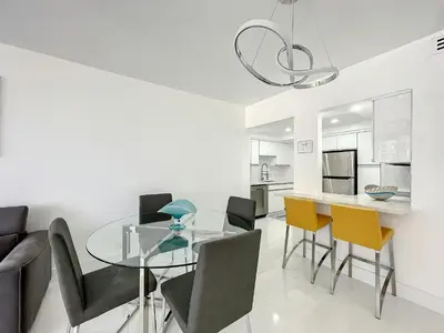 a dining room with a glass table and chairs at Beach Paradise a cozy ocean view condo on the beach with free parking in Hollywood
