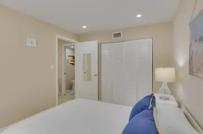 a white bedroom with a bed and a lamp at Refreshing Miami Apartment 4 Mi to the Beach! in Miami