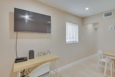 a room with a desk and a flat screen tv on the wall at Refreshing Miami Apartment 4 Mi to the Beach! in Miami