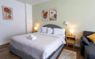 a bedroom with a large white bed and a couch at Rooftop-Pool King Bed Suite on Ocean Dr C305 in Miami Beach