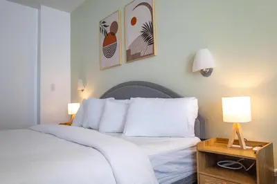 a bedroom with a bed with white sheets and pillows at Rooftop-Pool King Bed Suite on Ocean Dr C305 in Miami Beach