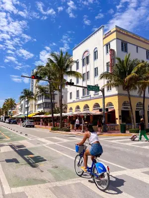 a person riding a bike on a city street at Rooftop-Pool King Bed Suite on Ocean Dr C305 in Miami Beach