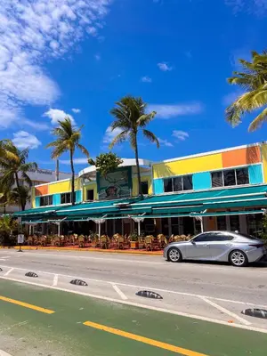 a car parked in front of a building with palm trees at Rooftop-Pool King Bed Suite on Ocean Dr C305 in Miami Beach
