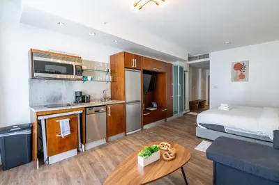a room with a bed and a kitchen and a living room at Rooftop-Pool King Bed Suite on Ocean Dr C305 in Miami Beach