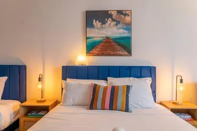 a bed with a blue headboard and a painting above it at King bed Rooftop Suite Ocean Dr C304 in Miami Beach