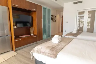 a bedroom with two beds and a flat screen tv at Rooftop-Pool Suite on Ocean Dr C505 in Miami Beach
