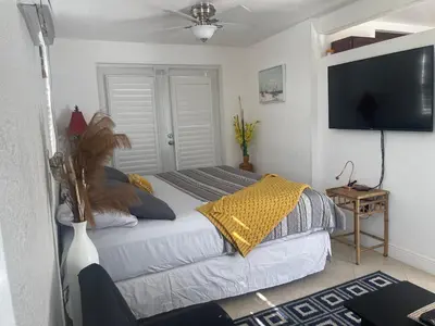 a bedroom with a bed and a flat screen tv at Master King Suite by Hard rock stadium and casino in Miami