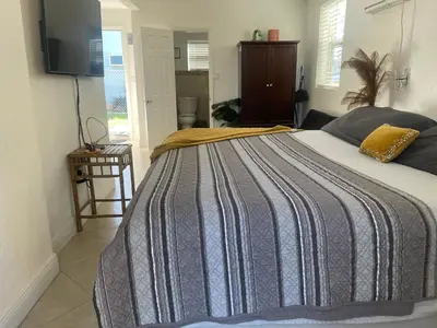 a bedroom with a bed with a striped blanket at Master King Suite by Hard rock stadium and casino in Miami