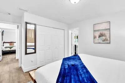 a bedroom with a bed with a blue blanket on it at Estelo's Place - Modern townhouse with King bed, only 5 min from the Airport! in Miami