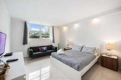a white room with a bed and a couch at 2-Bedroom Beach Condo in Sunny Isles in Miami Beach