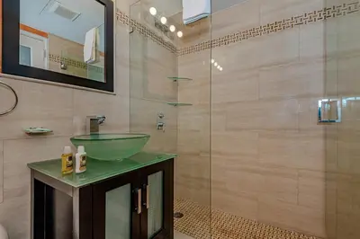 a bathroom with a sink and a glass shower at Beach Front Studio Miami Beach in Miami Beach