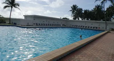 a large swimming pool with a person in the water at Beach Front Studio Miami Beach in Miami Beach