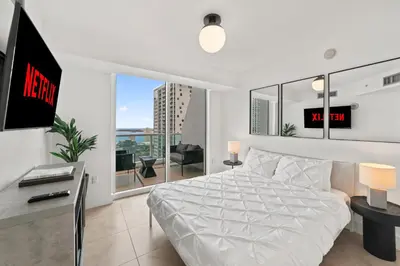 a bedroom with a white bed and a large window at Skyline Serenity - Brickell On The River - Bi-Level Loft with Breathtaking Views On The Ocean in Miami
