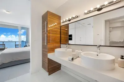 a bathroom with two sinks and a bed and a mirror at Lunabase Waterfront Paradise in Miami