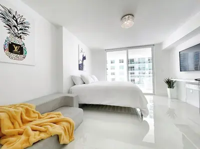 a white bedroom with a bed and a couch at Blissful Sky Residence with Ocean and City Views in Miami
