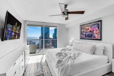 a white bedroom with a bed and a large window at Majestic Penthouse with Ocean and City Views in Miami