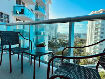 a balcony with chairs and a table with a view of the city at Oceanview Beachfront Condo on Tides Resort in Hollywood