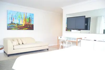 a living room with a couch and a flat screen tv at Victoria Park Hotel in Fort Lauderdale