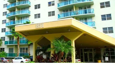 a large building with palm trees in front of it at ⌘Family Beach Home w Amazing Water Views - Upgraded Unit ⌘ in Miami Beach