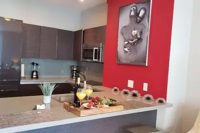 a kitchen with red walls and a counter with fruit on it at Amazing Studio Located in Upscale-Prime Location. Walking Distance to Restaurant in Miami