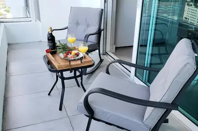 a balcony with two chairs and a table with two glasses of wine at Amazing Studio Located in Upscale-Prime Location. Walking Distance to Restaurant in Miami