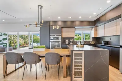 a kitchen with a large wooden table and chairs at Miami Paradise - Htd Pool, Mini Golf, Playground, BBQ, Arcade Machine, baby items in Miami