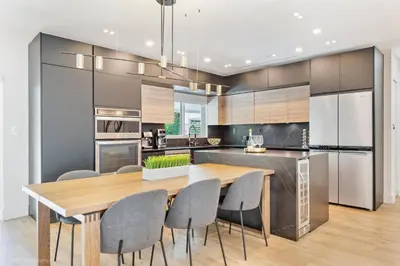 a kitchen with a wooden table and gray chairs at Miami Paradise - Htd Pool, Mini Golf, Playground, BBQ, Arcade Machine, baby items in Miami