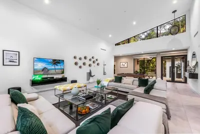 a living room with white furniture and a tv at Coconut Grove Villa with heated Pool sleeps 12 in Miami